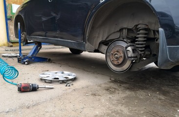 Unscrewed wheels on a car with a tire fitting.