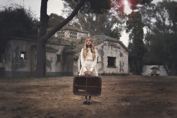 Girl with suitcase in old house

