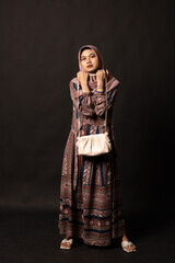Fototapeta premium Beautiful stylish girl holding bag on black background