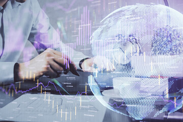 Double exposure of man's hands holding and using a phone and financial graph drawing. Analysis concept.