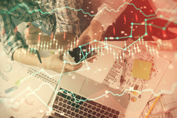 Double exposure of forex graph drawing and man and woman working together holding and using a mobile device. Trade concept.