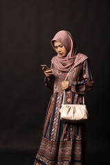 Beautiful stylish girl holding bag on black background