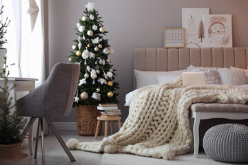 Beautiful decorated Christmas tree in bedroom interior