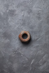 Old rusty nut close-up on a dark gray background. Parts of industrial machines. Verical photo.