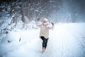 Fototapeta na wymiar Cheerful girl enjoying beautiful winter full of snow