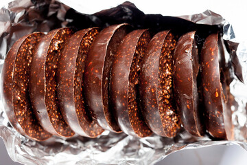 handmade chocolates without heat treatment with air amaranth. lie on a black granite table. raw food diet concept.