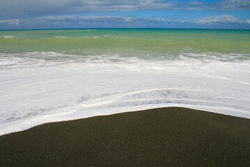 Whirinaki beach near Napier. Dark volcanic rocks and sand, black coloured beach, Hawke's Bay, Napier, North Island, New Zealand
