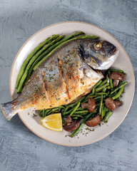 Grilled spicy fish served with asparagus and green beans.Colorful food art composition on plate. Top view.