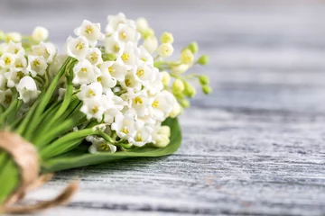 Fotobehang Lelie van dalen Bouquet of lilies of the valley on the blue wooden board  © Ivanna Pavliuk