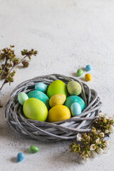 Obraz na płótnie Canvas colorful easter eggs in a nest on a light background