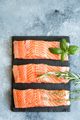 Salmon. Fresh raw salmon fish fillet with cooking ingredients, herbs and lemon. Close up. healthy food, diet or cooking concept
