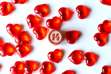 Festive background: a lot of red hearts on a white background, lying randomly and the number 14 in...