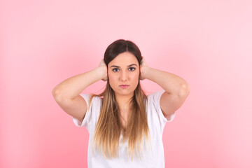 Fototapeta premium young woman covers her ears with both hands. Excessive noise
