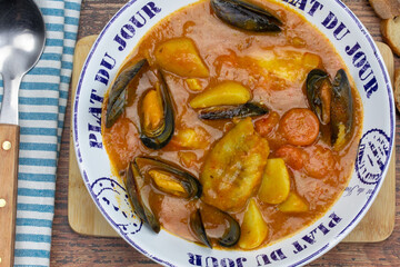 assiette de bouillabaisse sur une table en bois