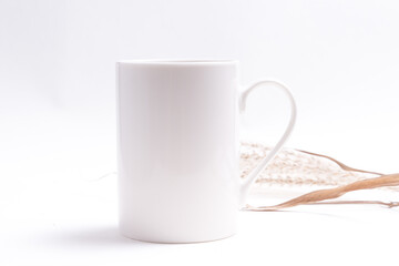 White porcelain coffee cup decorated with dried grass