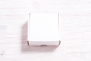White cardboard carton box on wooden desk, flat lay mock up
