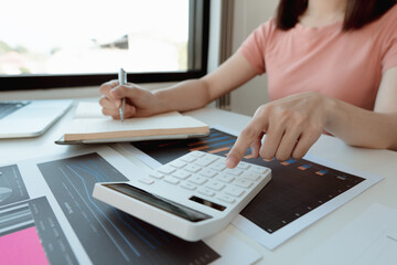 businessman working on desk office with using a calculator to calculate the numbers, finance accounting concept