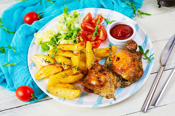 Delicious baked chicken with potatoes on wooden background