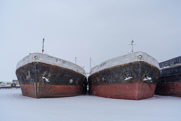 Ships at the winter anchorage in the port. The water is frozen. Front view of the ship.