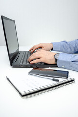 A man working on the laptop with notebook and calculator in the office