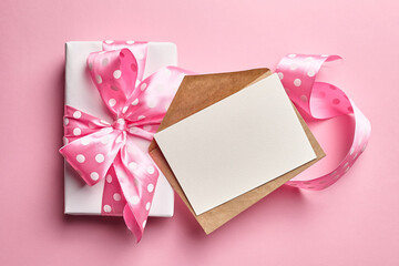 Greeting card mockup with gift box on pink background