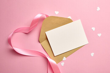Greeting card mockup with pink ribbon and white paper hearts