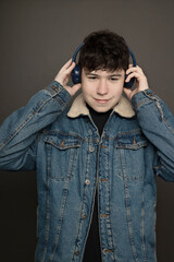 teenager in jean jacket listening to happy music on headphones