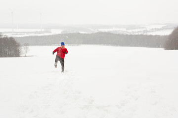 Man kicks the snow playing under a snow storm