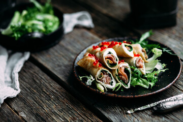 Thin Pancakes with salmon, spinach and red caviar. Breakfast. Maslenitsa holiday
