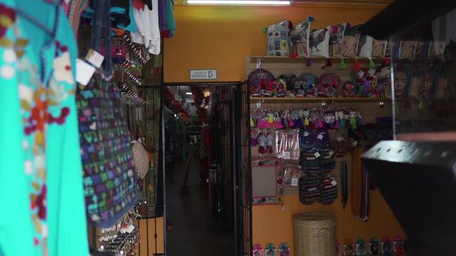Hispanic girl going inside traditional Mexican souvenir shop - Medium shot