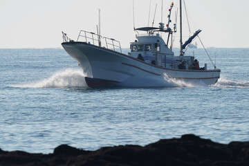 Fototapeta na wymiar fishing boat returns to port