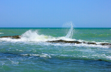 Fototapeta premium Waves crash against underwater rocks.