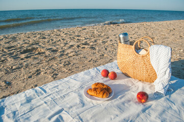 Summer picnic on the beach by the sea at a sunrise.