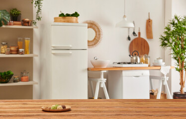 Close up wooden table and decorative kitchen background style. Refrigerator, dishwasher and stove style with lamp concept.
