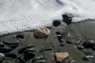 Beach stones and sea foam