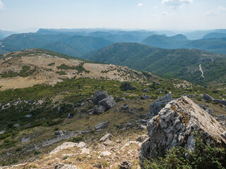 View from white limestone tower Perda Liana, impressive rock boulders, green forest hill and mountain. National Park of Barbagia, Central Sardinia, Italy, summer day