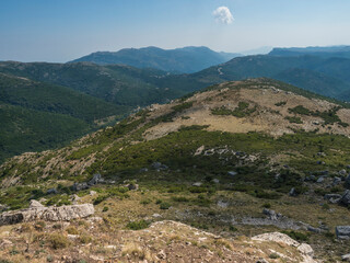 View from white limestone tower Perda Liana, impressive rock boulders, green forest hill and mountain. National Park of Barbagia, Central Sardinia, Italy, summer day
