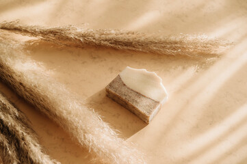 Handmade soap and pampas grass. Sunshade shadow on beige background. Zero waste, eco friendly...