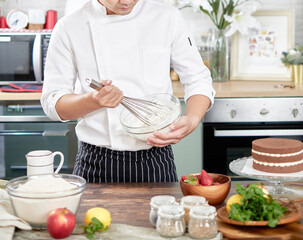 Pastry bakery chef in the kitchen preparing cake. bakery and food concept.