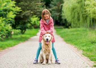 Little girl standing with dog between feet