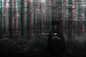 witch in a black costume with candles in her hands performs an occult ritual and mystical spells in a dark forest