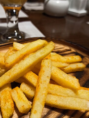 Close up wooden plate with fish and chips, fast food topic,   tasty fries and burger, cafe food