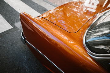 Coche clásico de color naranja con un paso de peatones al fondo (automóvil clásico americano)