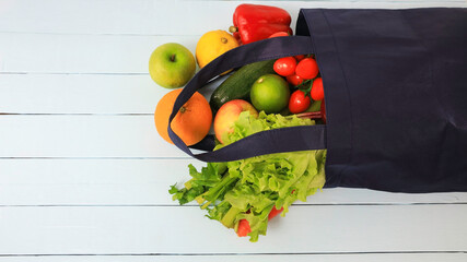 Selective focus of Reusable cloth bag for reduce plastic bag when shopping with Fruit and vegetable  on wooden table background