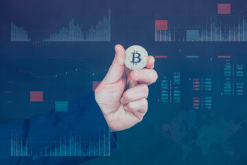 Businessman holds a gold bitcoin coin in his hands. Information holographic panel with statistics shows the fall and growth of the cryptocurrency. Virtual currency and blockchain concept.