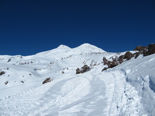 Fototapeta na wymiar Mount Elbrus with two peaks against a blue sky on a bright sunny day, close-up