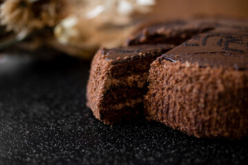 Sliced tasty chocolate cake. Chocolate cake with a cut piece on blurred background, closeup