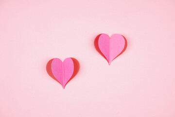 Obraz na płótnie Canvas Heart shaped paper sticked on pink background. Emblem of love for happy women, beloved mother, birthday cards and valentine greeting designs. Valentine's day backgrounds. Templates to convey our love.