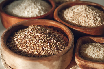 Set of different types of rice and cereals in wooden bowls