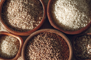 Set of different types of rice and cereals in wooden bowls